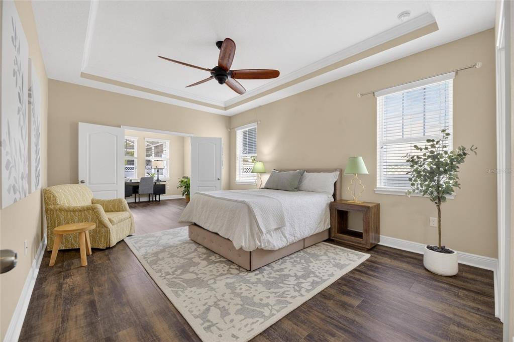 A bedroom with wood-look flooring, a tray ceiling, a ceiling fan, and an adjoining office — 513 MANNS HARBOR DRIVE, APOLLO BEACH, FL