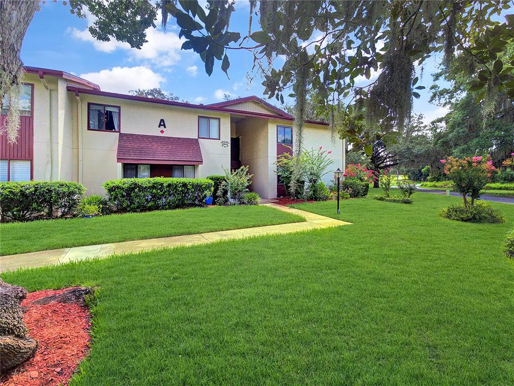A two-story apartment building with a tan exterior and a red roof labeled A — 700 MIDWAY DRIVE UNIT B, OCALA, FL