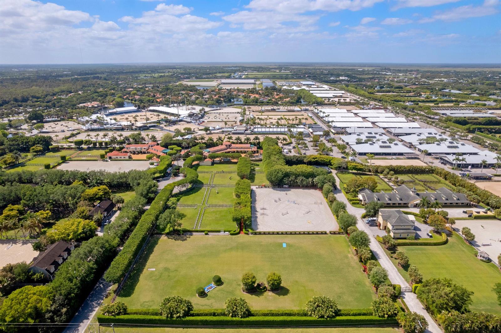 An aerial view shows a large equestrian estate with multiple riding arenas, stables, and paddocks — 3151 Hickstead Place, Wellington FL 33414, WELLINGTON, FL
