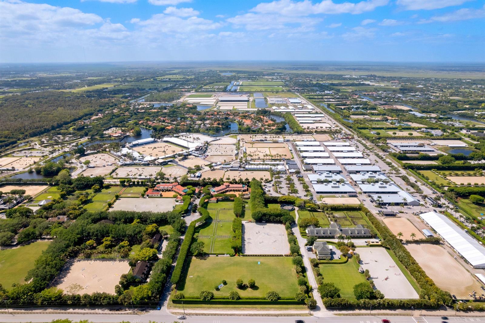 An aerial view shows a large equestrian facility with multiple riding arenas and stable buildings — 3151 Hickstead Place, Wellington FL 33414, WELLINGTON, FL