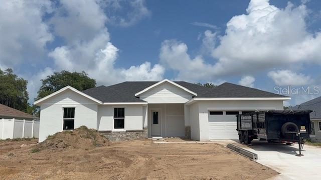 A newly constructed single-story house with a white exterior, stone accents, and a two-car garage — 140 FRONTIER DRIVE, PALM COAST, FL