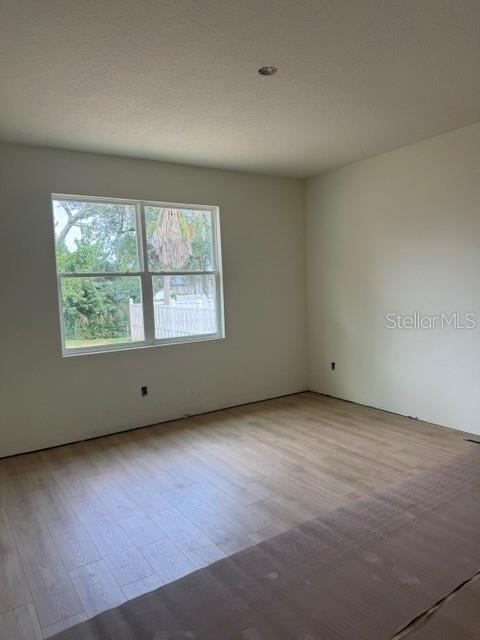 An empty room features light-colored wood-look flooring, off-white walls, and a single window — 140 FRONTIER DRIVE, PALM COAST, FL