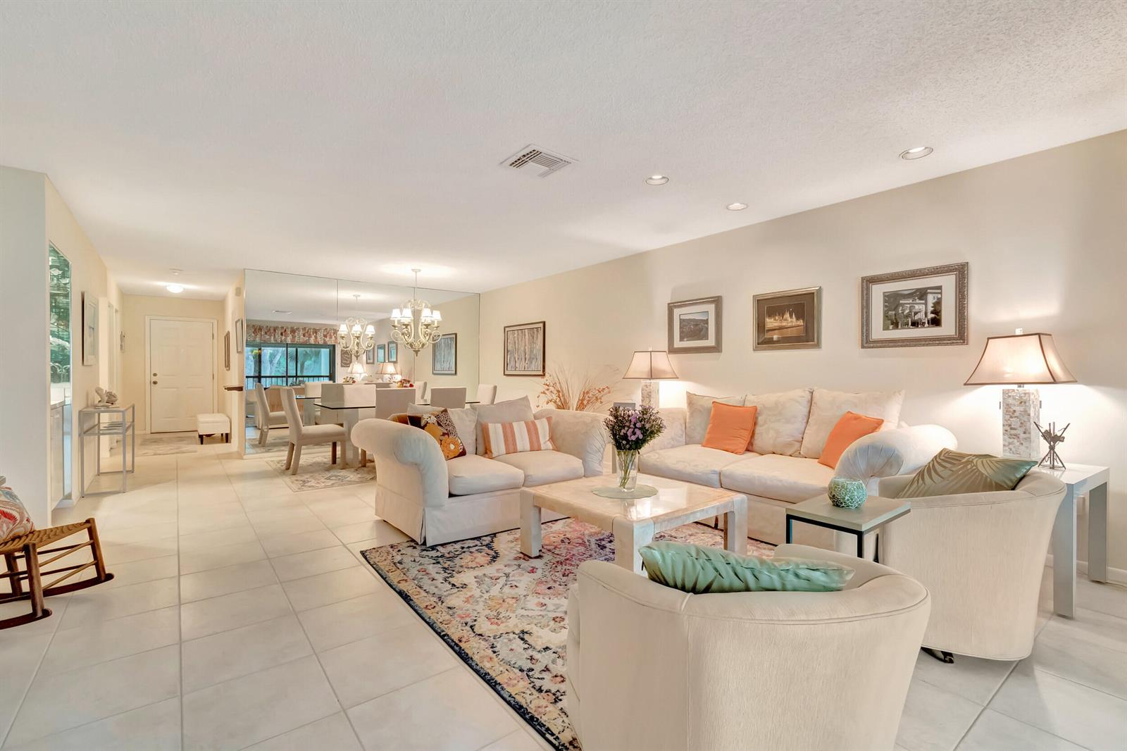 A bright living room features light tile floors, a patterned area rug, and neutral furniture — 19 Westgate Lane # 19f, Boynton Beach FL 33436, BOYNTON BEACH, FL