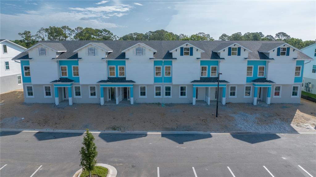 An exterior view of a multi-unit townhouse building with blue and white siding — 183 PEGASUS STREET, DAVENPORT, FL