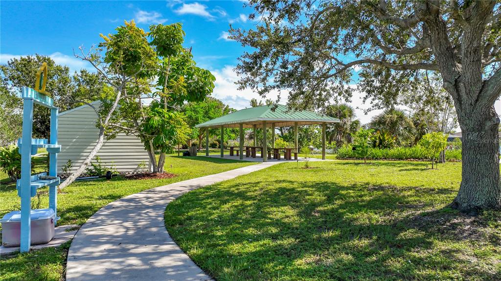 A paved walkway leads past a small shed and a picnic pavilion in a park — 9357 AGATE STREET, PORT CHARLOTTE, FL