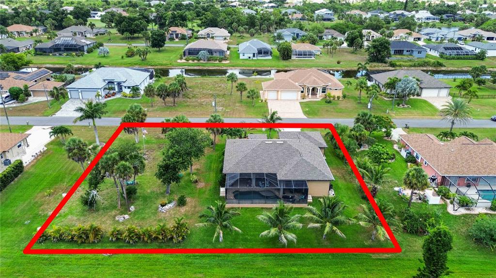 An aerial view shows a single-story house with a screened pool enclosure and large yard — 227 LONG MEADOW LANE, ROTONDA WEST, FL