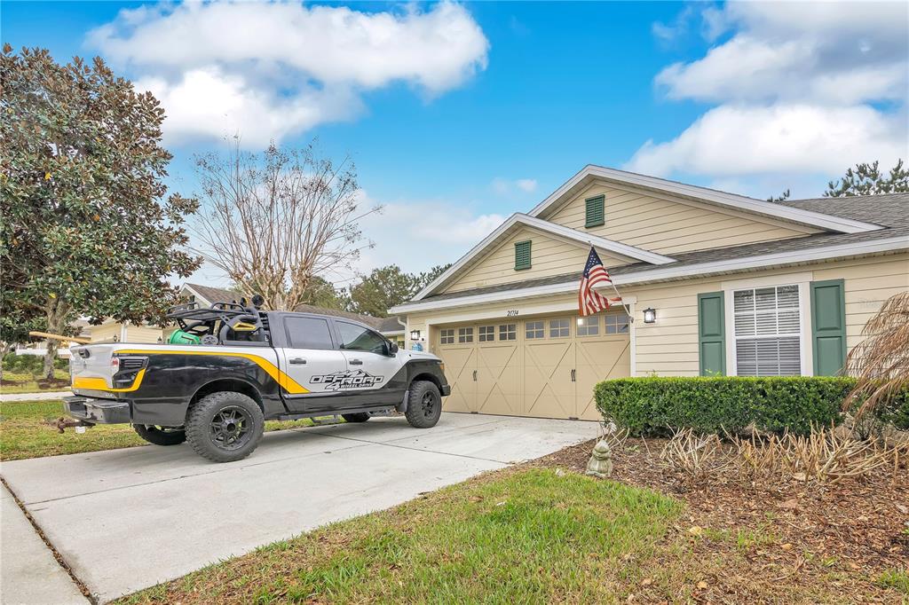 A light-colored house with a two-car garage and a pickup truck parked in the driveway — 21714 BELGIAN COURT, MOUNT DORA, FL