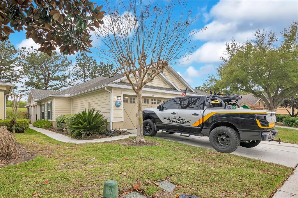 A light-colored single-story house with a garage and a pickup truck parked in the driveway — 21714 BELGIAN COURT, MOUNT DORA, FL