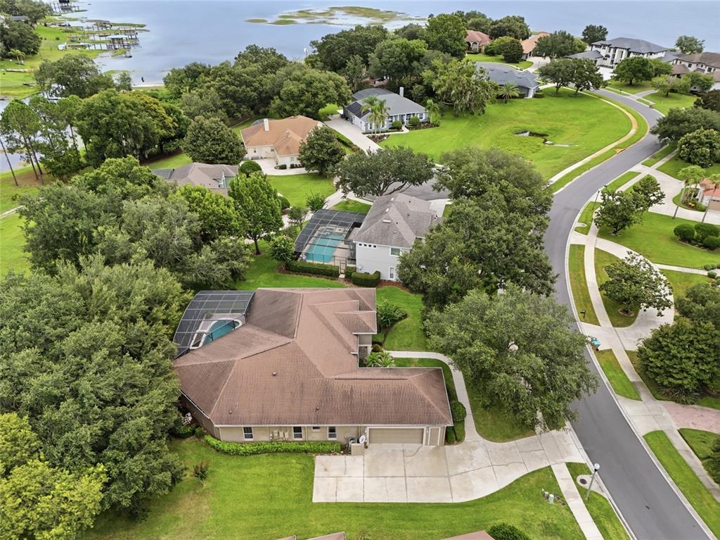 An aerial view shows a suburban house with a pool enclosure and a paved driveway — 17535 COBBLESTONE LANE, CLERMONT, FL