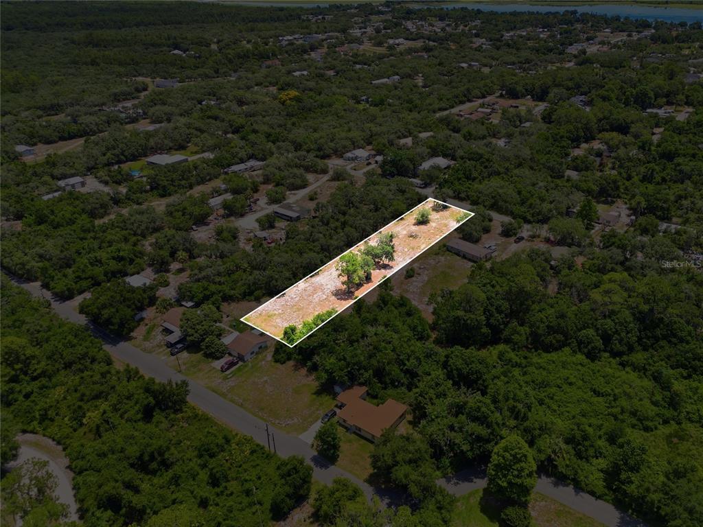 An aerial view shows a rectangular, cleared lot surrounded by trees and residential properties — HARTMAN RD, LAKE WALES, FL