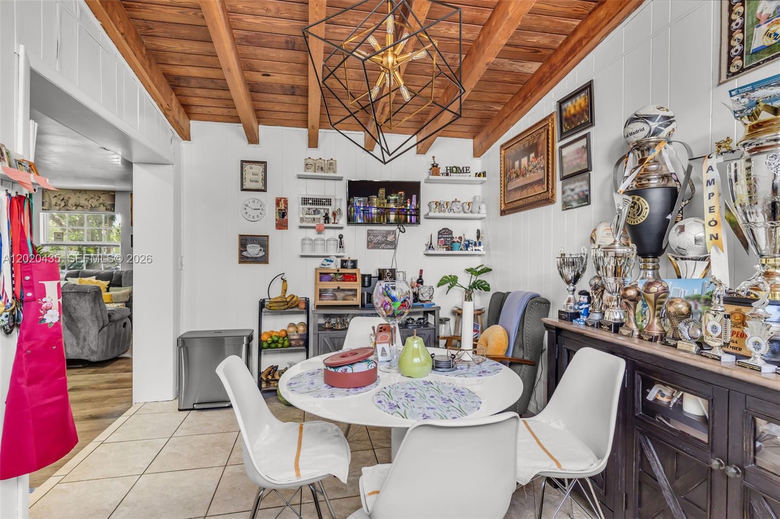 A dining room features a round white table, modern chairs, and a large geometric chandelier — 13075 NW 16th Ave, North Miami FL 33167, NORTH MIAMI, FL