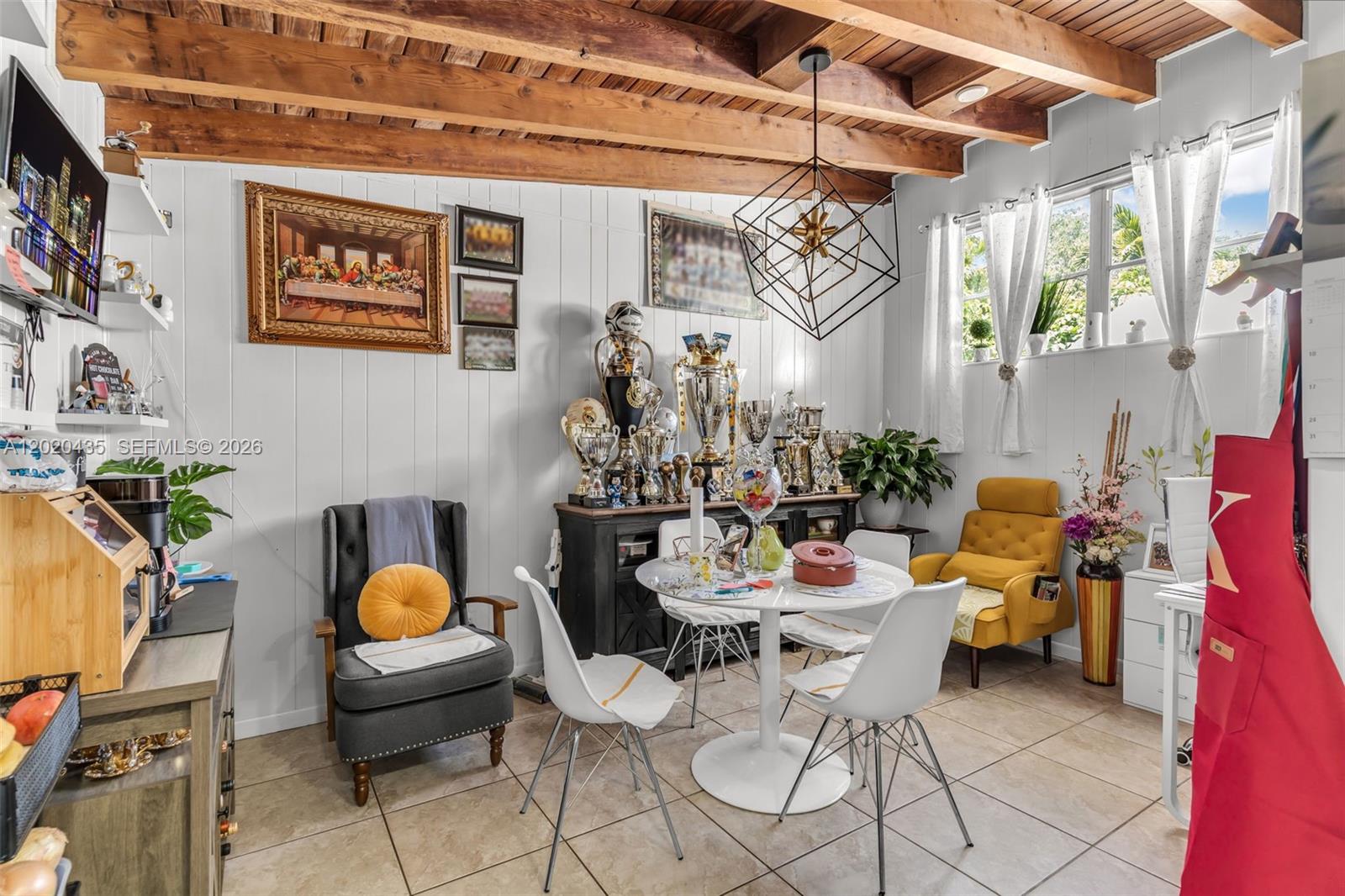 A dining area features a white table, modern chairs, a trophy display, and exposed wood beams — 13075 NW 16th Ave, North Miami FL 33167, NORTH MIAMI, FL