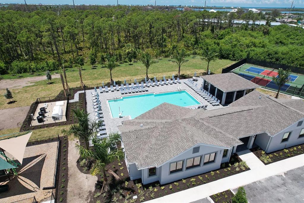 An aerial view of a community clubhouse featuring a swimming pool, tennis courts, and landscaping — 8535 SAINT KITTS CIRCLE, ENGLEWOOD, FL