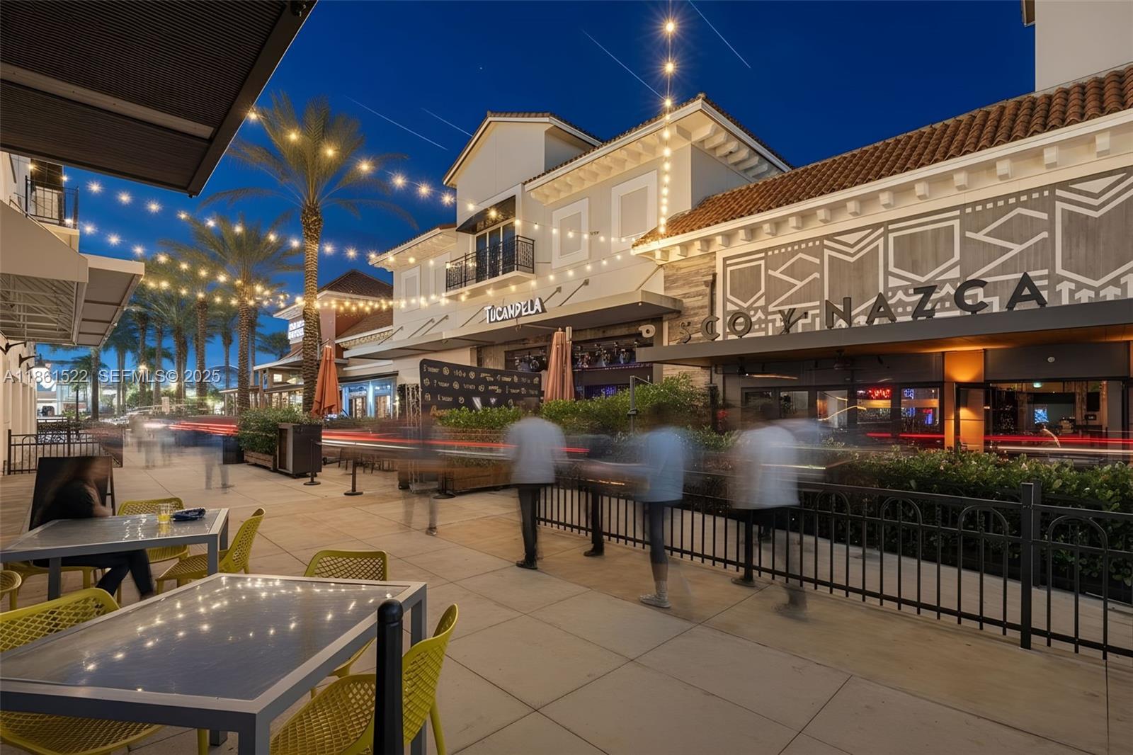 An outdoor dining area at a shopping center features tables, chairs, and string lights at dusk — Kendall Dr, Kendall FL 33183, KENDALL, FL