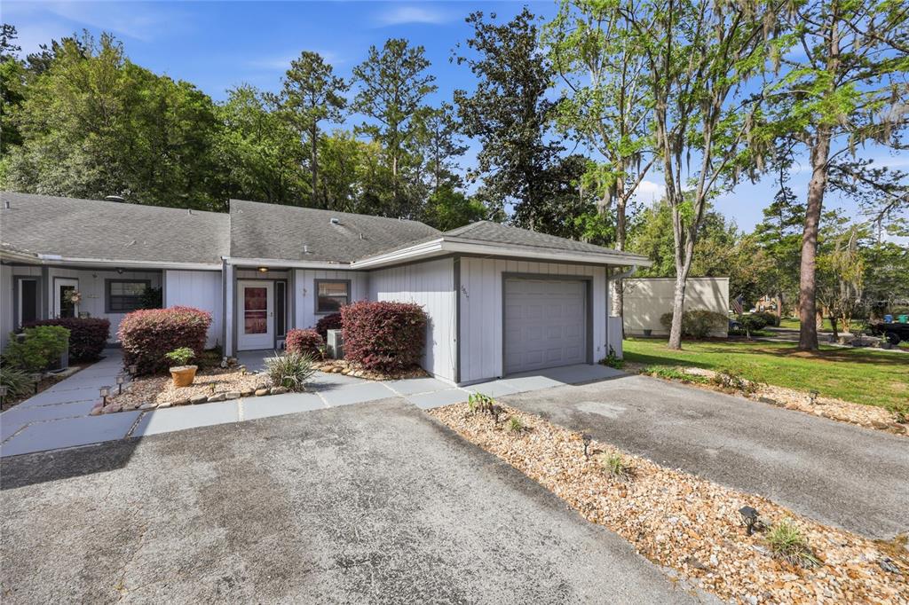 A single-story house with a gray garage, light siding, and a paved driveway — 6617 NW 114TH LANE UNIT 6617, ALACHUA, FL