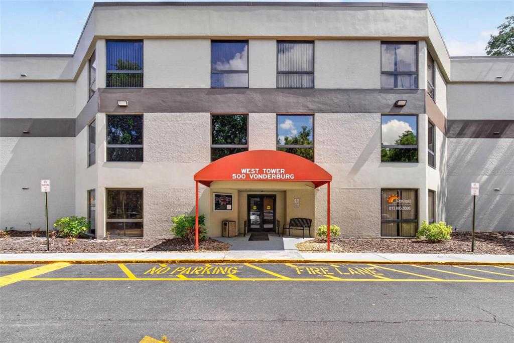 The exterior of a three-story commercial building features a red awning over the main entrance — 500 VONDERBURG DRIVE UNIT 314, BRANDON, FL
