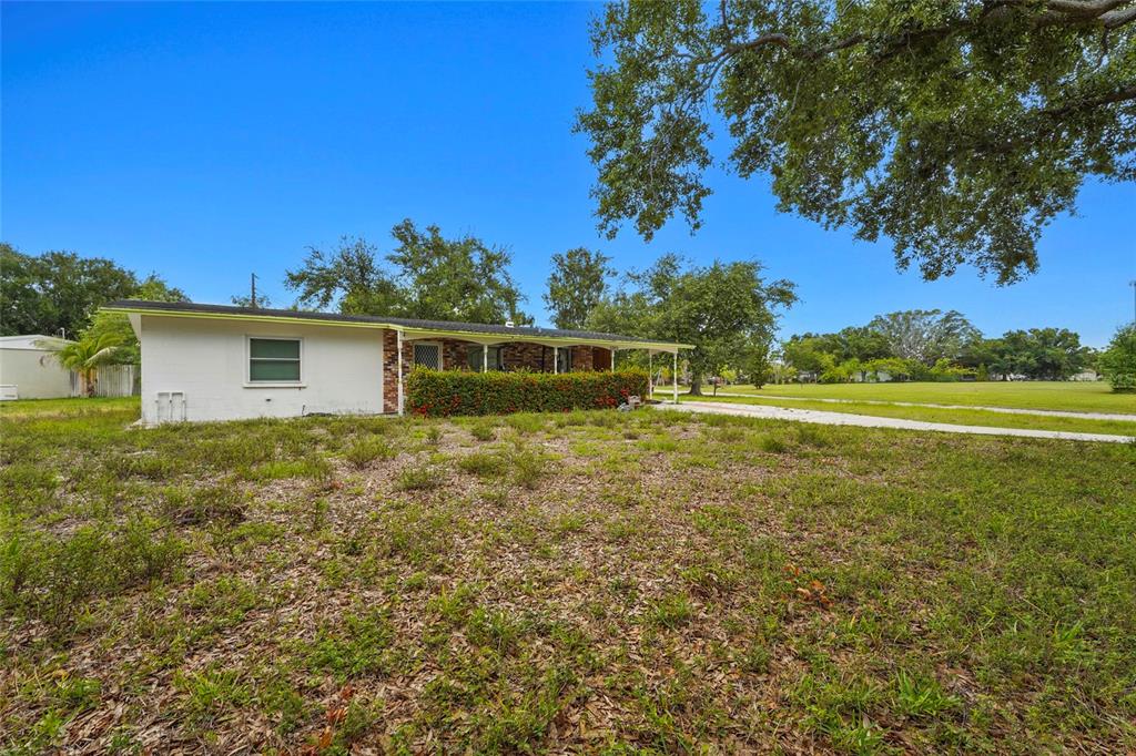 A single-story white house with a covered porch and a large, grassy front yard — 5320 41ST AVENUE W, BRADENTON, FL