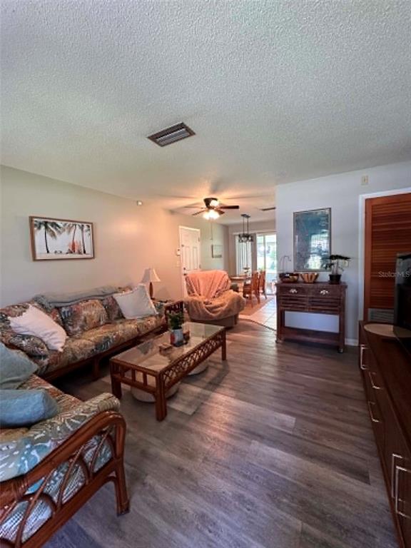 A living room features wood-look flooring, a rattan sofa, a coffee table, and a ceiling fan — 745 SE 29TH AVENUE, OCALA, FL