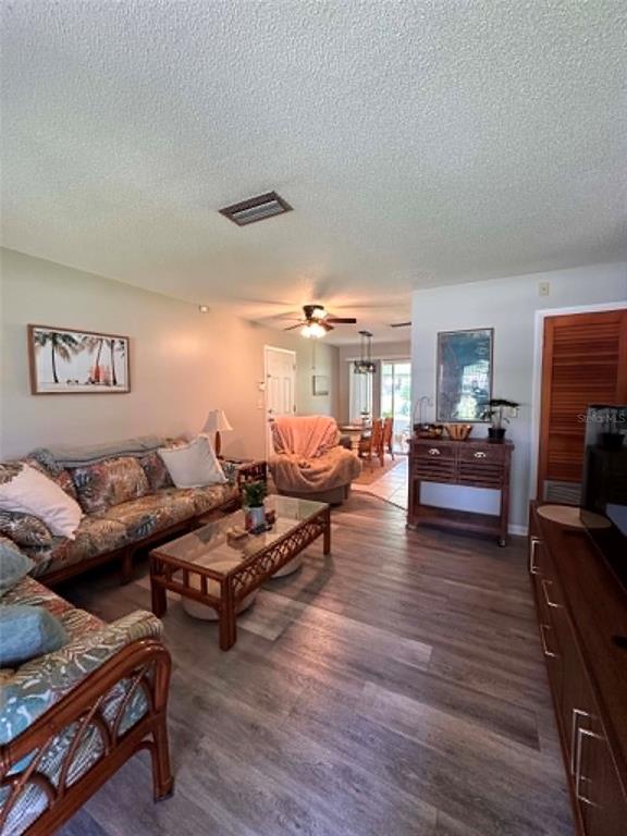 A living room features wood-look flooring, a rattan sofa, and an open dining area — 745 SE 29TH AVENUE, OCALA, FL