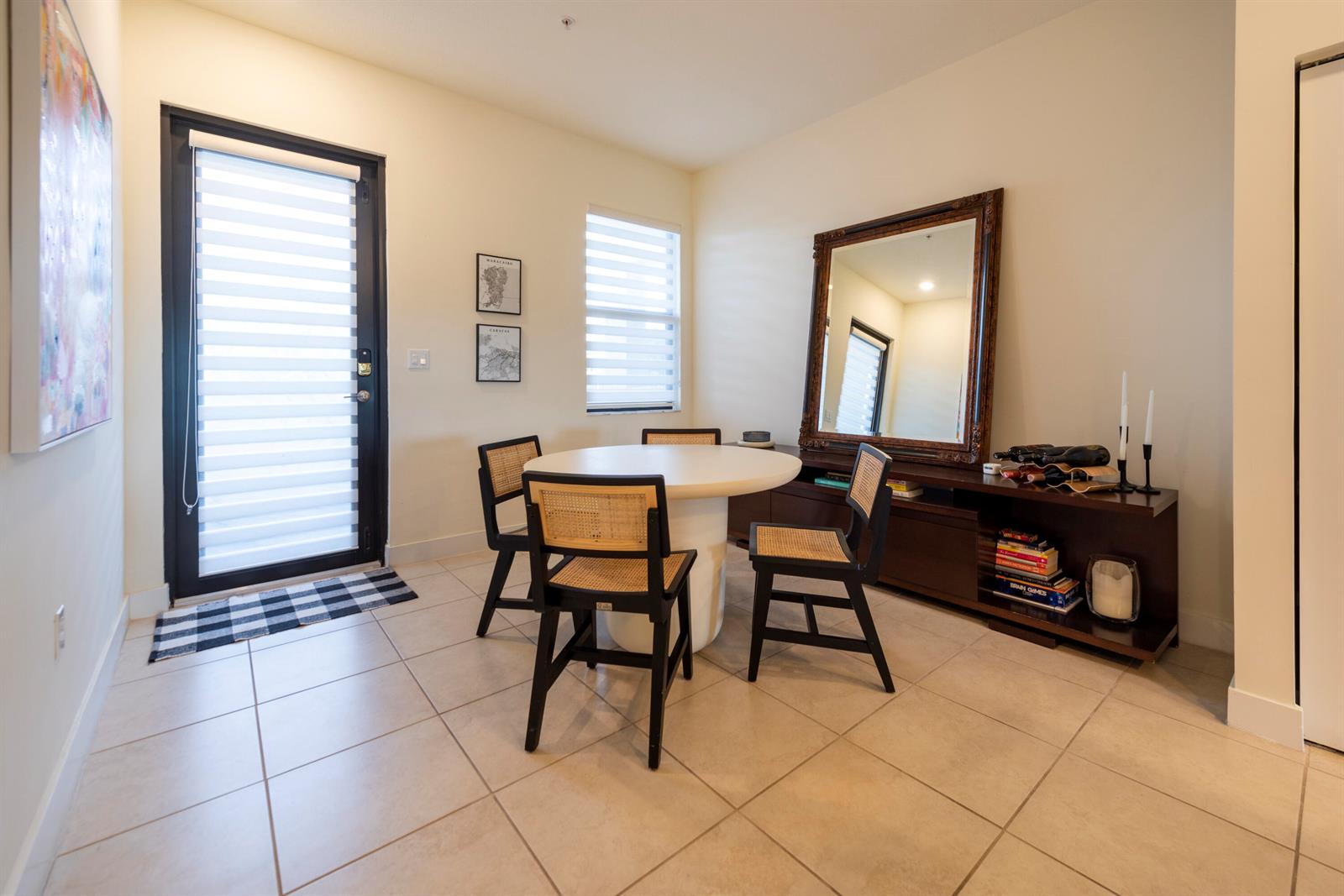 A dining room features a round white table, cane-back chairs, and a large wall mirror — 7925 NW 104th Avenue # 24, Doral FL 33178, DORAL, FL