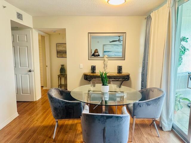 A dining area features a glass table, four gray velvet chairs, and a wall mirror — 402 Villa Circle # 402, Boynton Beach FL 33435, BOYNTON BEACH, FL