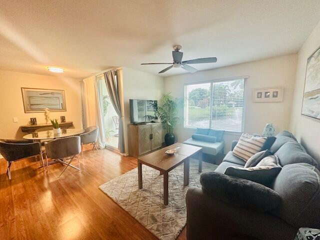 A living and dining room with hardwood floors, a ceiling fan, and a sliding glass door — 402 Villa Circle # 402, Boynton Beach FL 33435, BOYNTON BEACH, FL