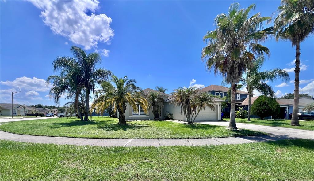 A single-story house with a two-car garage and palm trees in the front yard — 2950 ELBIB DRIVE, ST CLOUD, FL