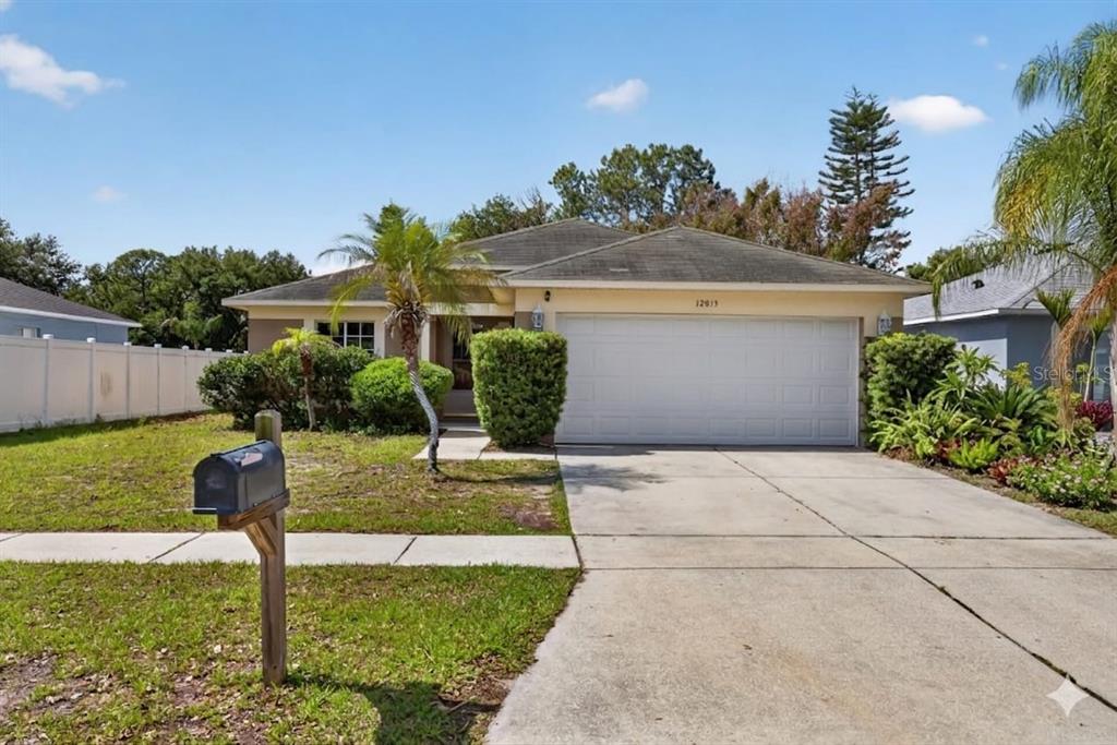 A single-story house with a white garage door, a concrete driveway, and a front lawn — 12015 CEDARFIELD DRIVE, RIVERVIEW, FL