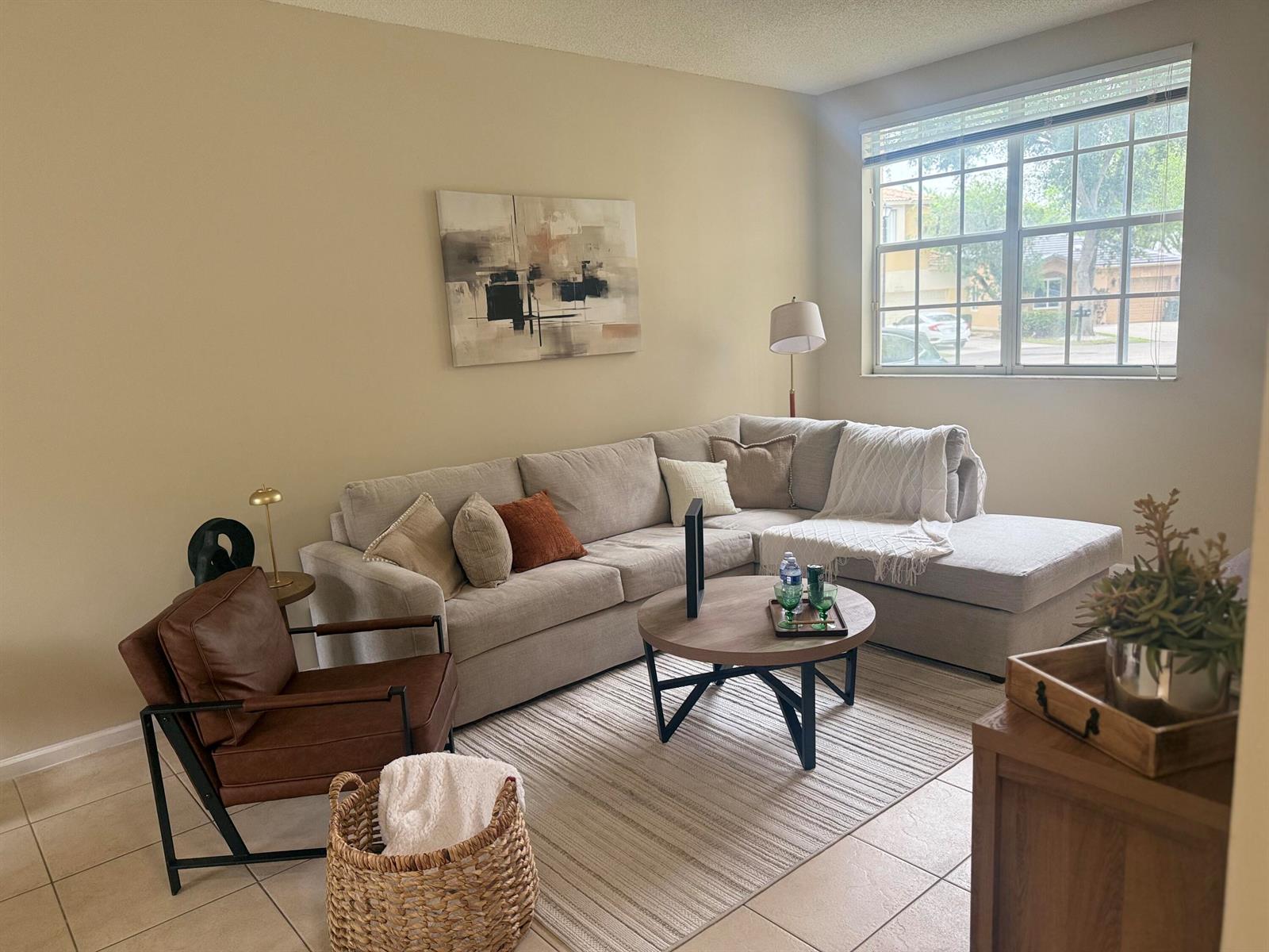 A living room features a beige sectional sofa, a leather armchair, and a round coffee table — 5203 Eagle Cay Place, Coconut Creek FL 33073, COCONUT CREEK, FL