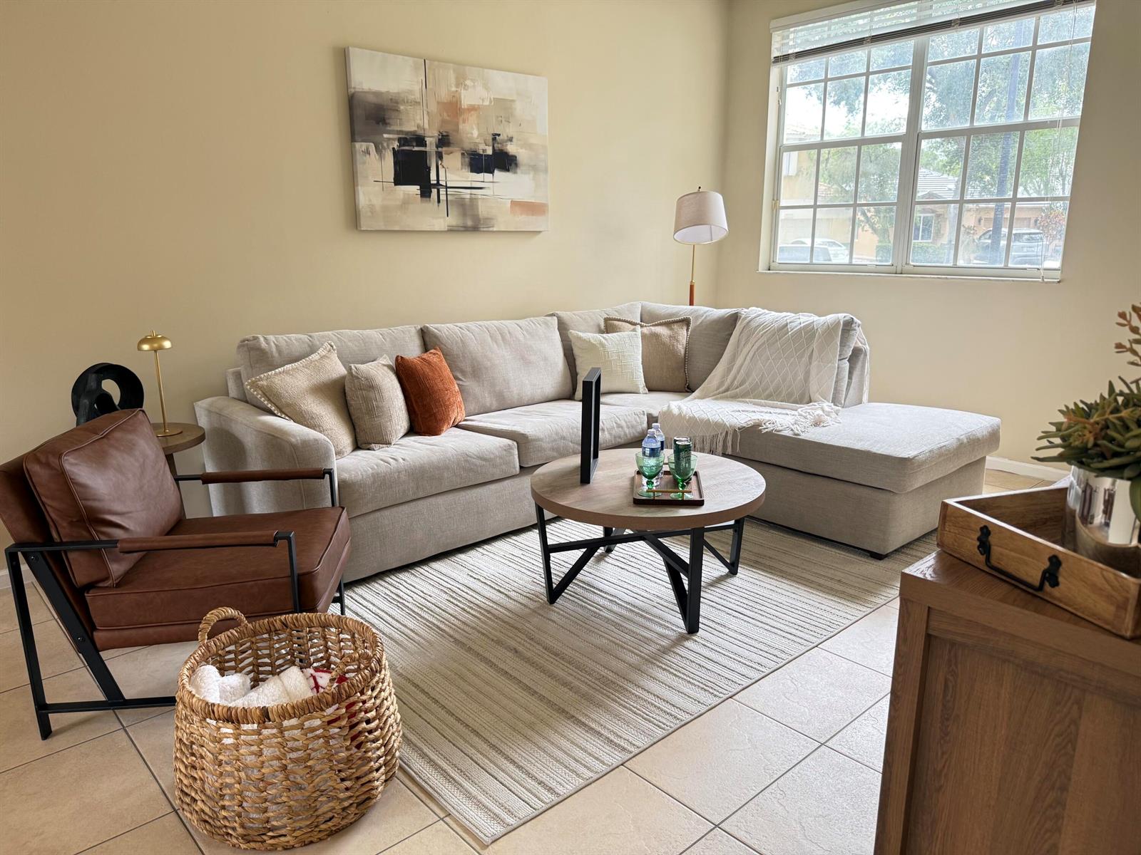 A living room features a beige sectional sofa, a leather armchair, and a round coffee table — 5203 Eagle Cay Place, Coconut Creek FL 33073, COCONUT CREEK, FL