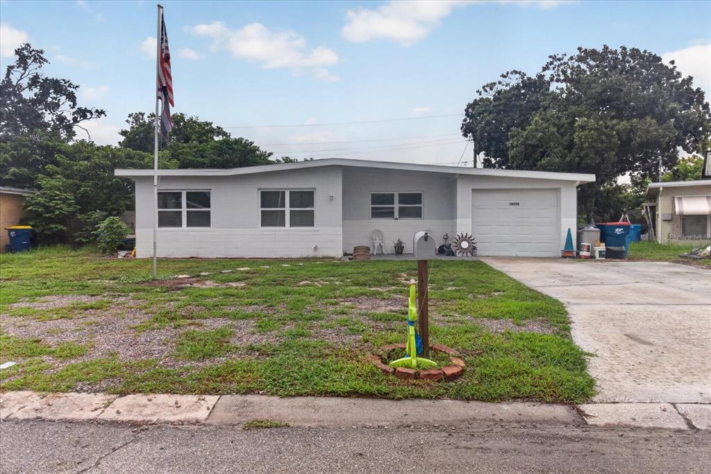 A single-story house with a gray exterior, a front lawn, and an attached garage — 10538 AGATE COURT, PORT RICHEY, FL
