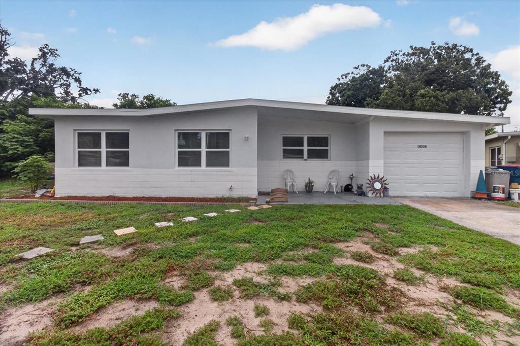 A single-story house with a gray exterior, a front porch, and an attached garage — 10538 AGATE COURT, PORT RICHEY, FL