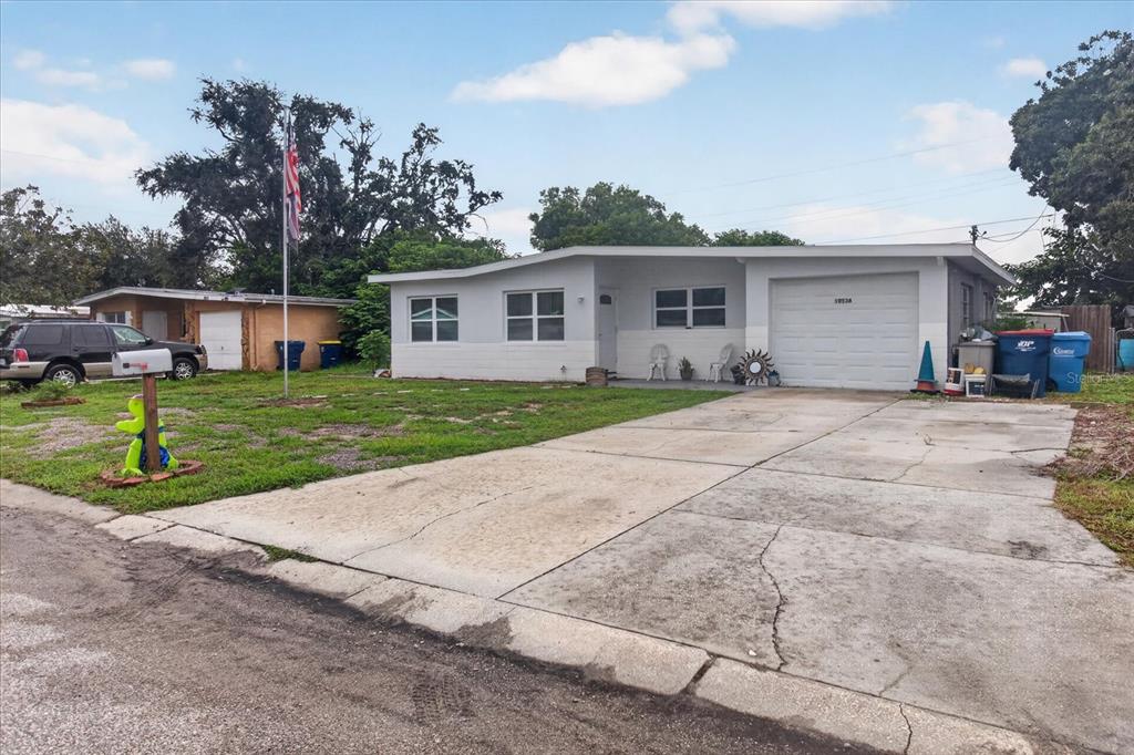 A single-story house with a concrete driveway, a garage, and a front yard with grass — 10538 AGATE COURT, PORT RICHEY, FL