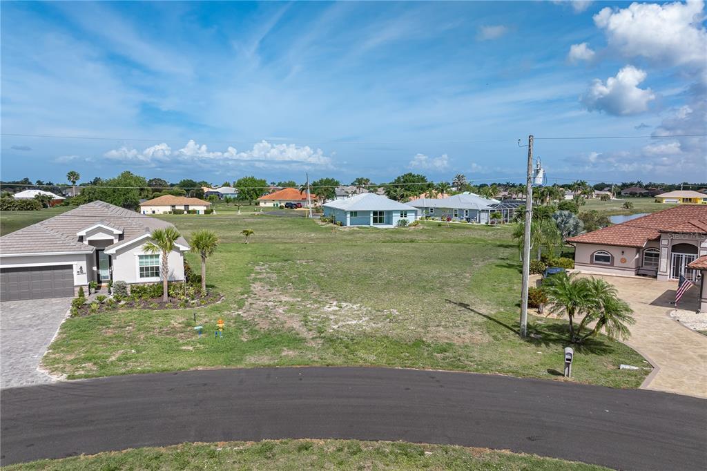 An elevated view of a vacant residential lot situated between two single-family homes — 17528 VELLUM CIRCLE, PUNTA GORDA, FL