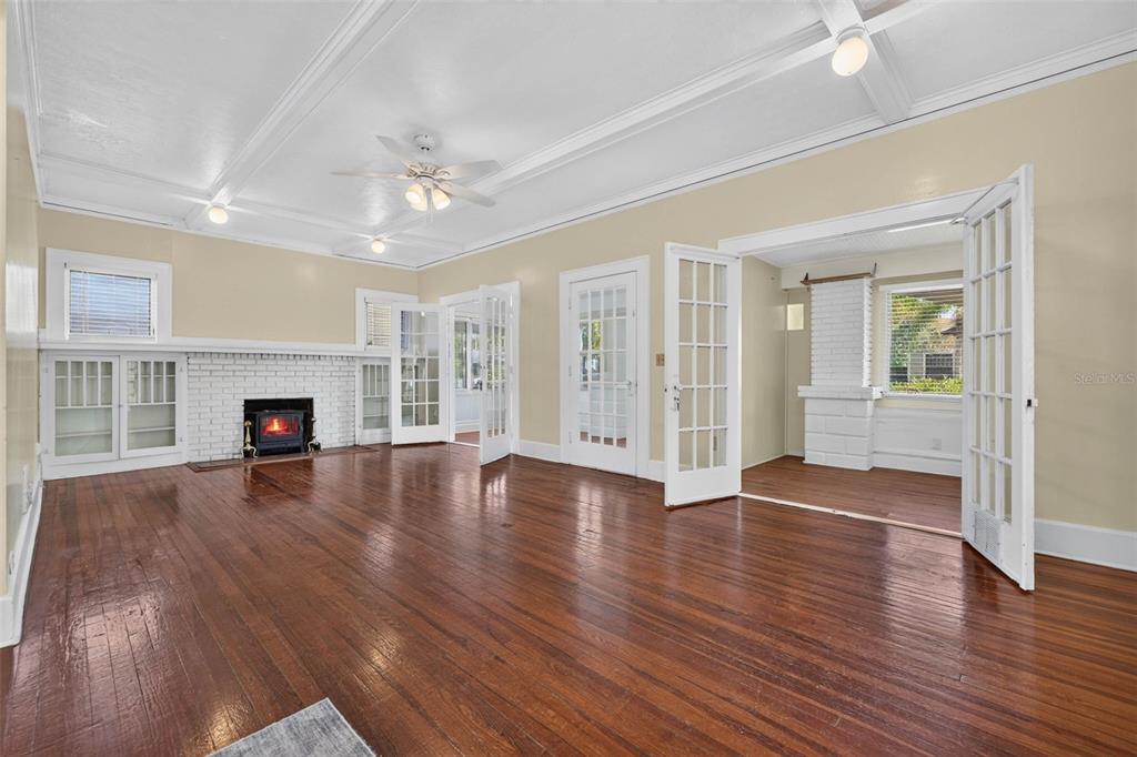 A living room with hardwood floors, a white brick fireplace, and French doors — 2800 2ND AVENUE N, ST PETERSBURG, FL