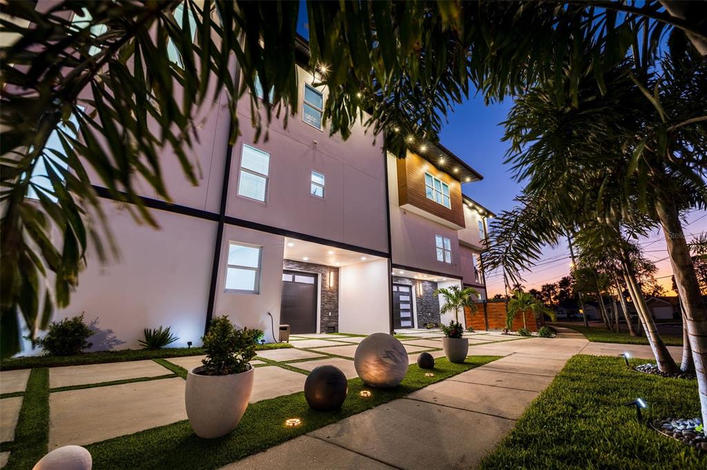 A modern multi-story building exterior features a paved driveway with grass strips and spherical sculptures — 6062 BAYOU GRANDE BOULEVARD NE, ST PETERSBURG, FL