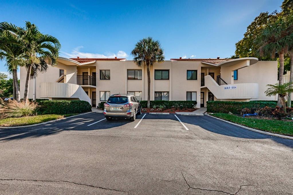 A two-story apartment building with a parking lot and palm trees in front — 5724 PUERTA DEL SOL BOULEVARD S UNIT 248, ST PETERSBURG, FL