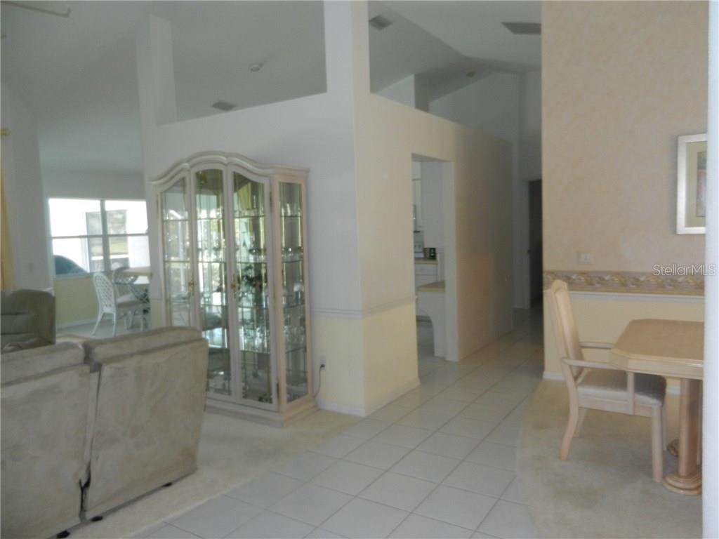 A living area features a glass display cabinet, tiled flooring, and a dining set — 589 ROTONDA CIRCLE, ROTONDA WEST, FL