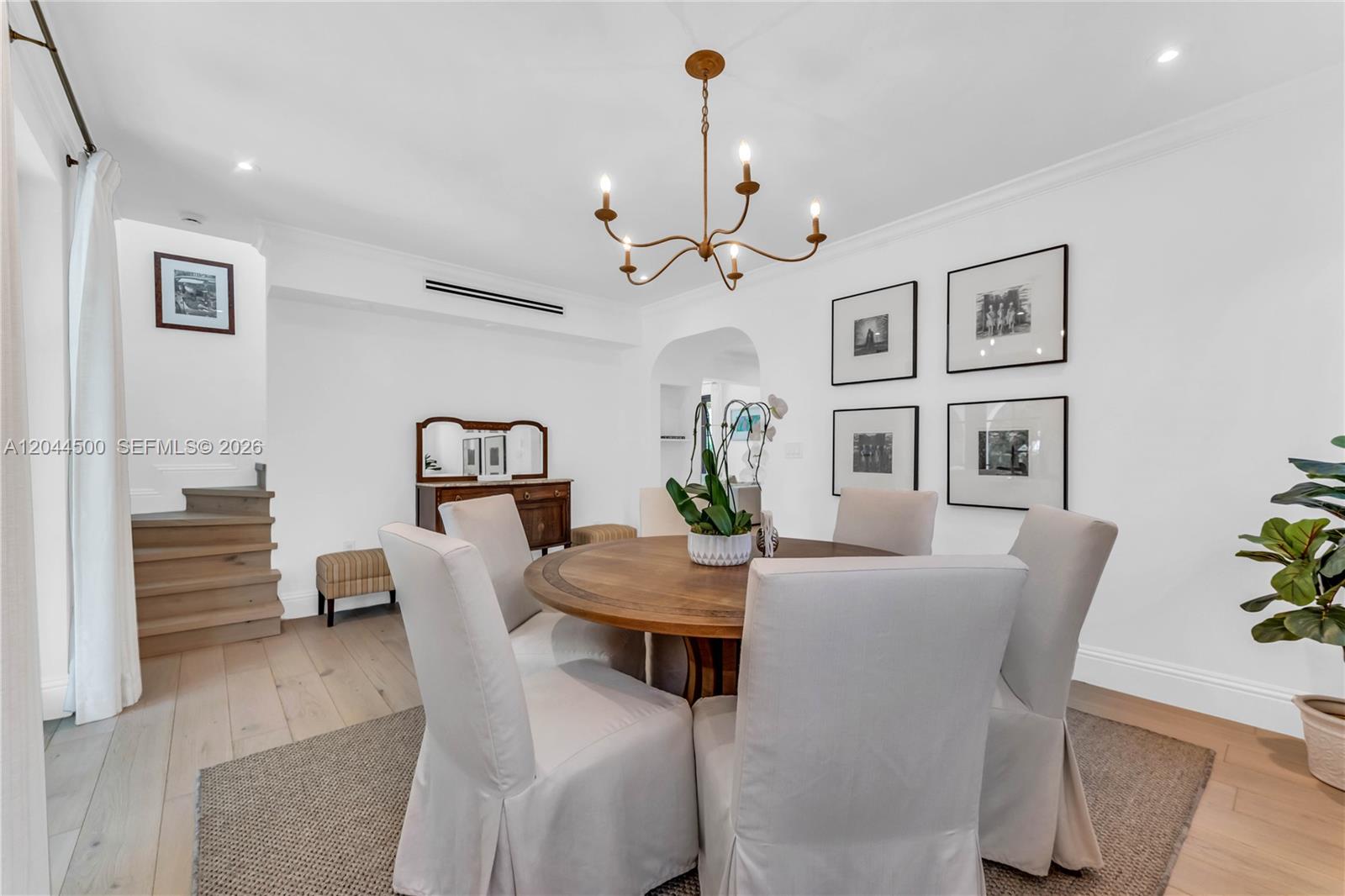 A dining room features a round wooden table, upholstered chairs, and a chandelier — 5730 SW 49th St, South Miami FL 33155, SOUTH MIAMI, FL