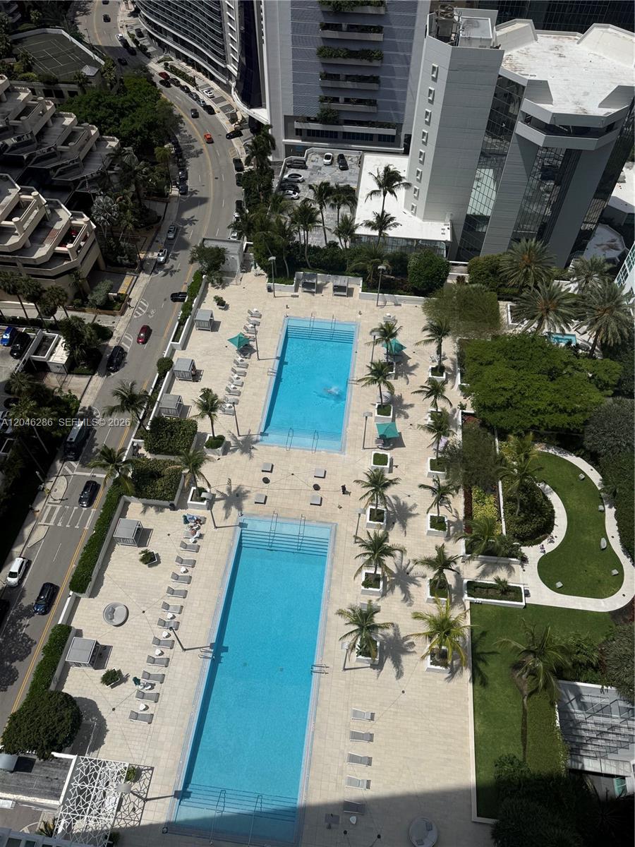 An aerial view shows two rectangular swimming pools surrounded by a patio and palm trees — 950 Brickell Bay Dr # 2907, Miami FL 33131, MIAMI, FL