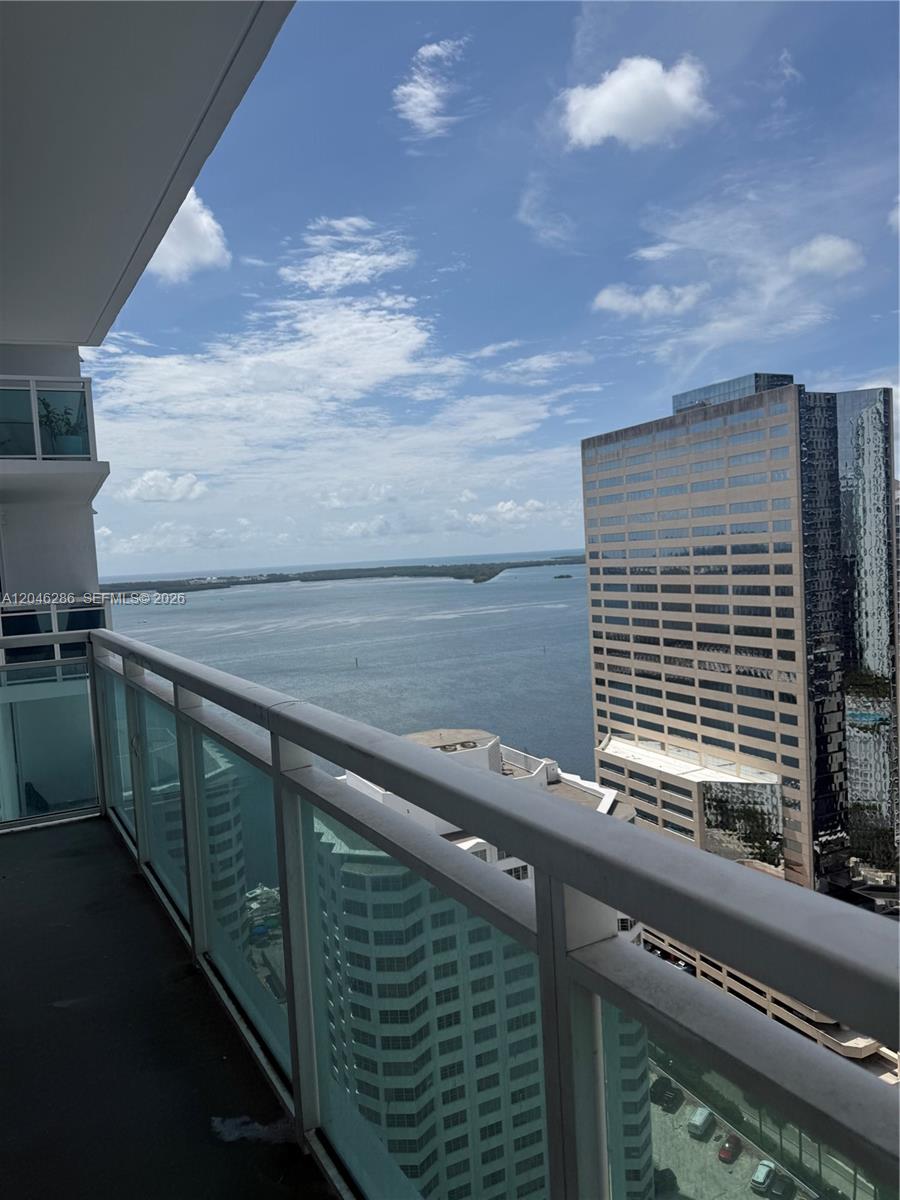 A high-rise balcony overlooks a large body of water and neighboring city buildings — 950 Brickell Bay Dr # 2907, Miami FL 33131, MIAMI, FL