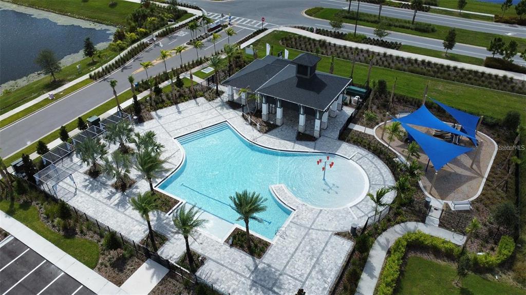 An aerial view of a community swimming pool with a pavilion and a shaded playground — 4806 PRAIRIE PRESERVE RUN, ST CLOUD, FL