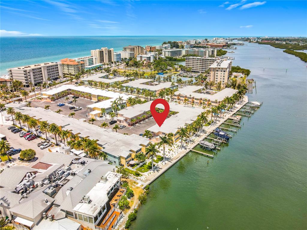 An aerial view shows a waterfront condominium complex with a red location pin — 19417 GULF BOULEVARD UNIT A-113, INDIAN SHORES, FL