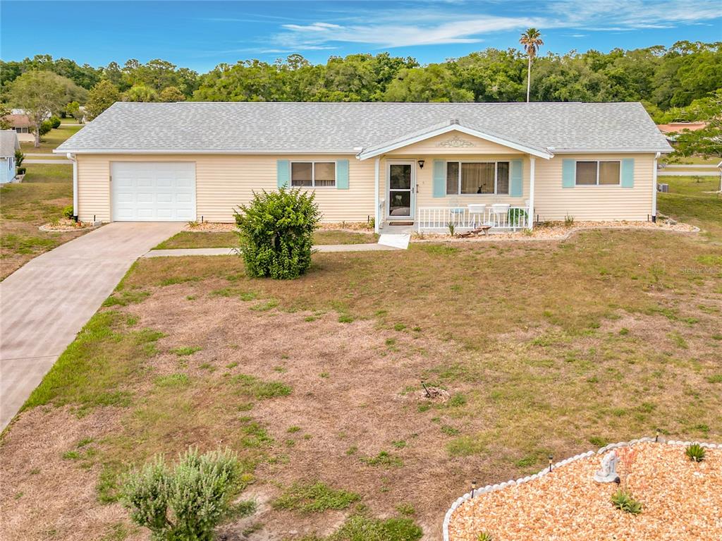 A single-story house with light yellow siding, a white garage, and a front porch — 8121 SW 107TH PLACE, OCALA, FL