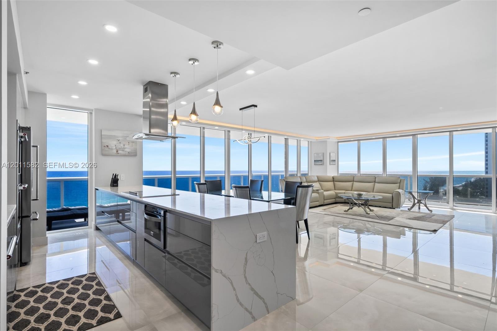 A modern open-concept kitchen and living area features floor-to-ceiling windows with ocean views — 1830 S Ocean Dr # 1002, Hallandale Beach FL 33009, HALLANDALE BEACH, FL