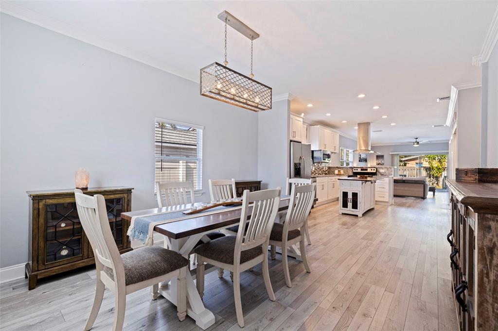 A dining area with a wooden table and chairs sits adjacent to an open kitchen — 3110 15TH STREET N, ST PETERSBURG, FL
