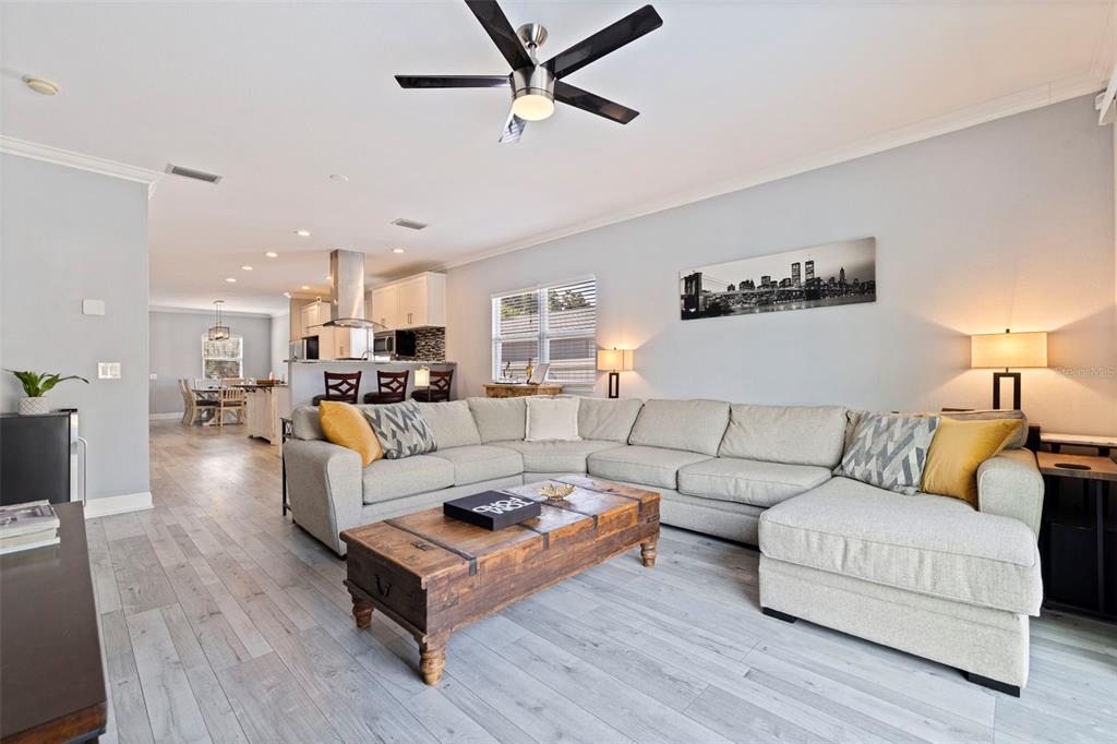 A living room with a large sectional sofa, wooden coffee table, and open kitchen area — 3110 15TH STREET N, ST PETERSBURG, FL