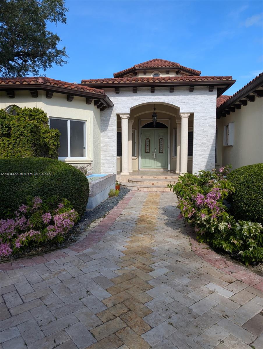 The exterior view shows a house entrance with a stone walkway and a tiled roof — 13400 SW 83rd Ave, Pinecrest FL 33156, PINECREST, FL
