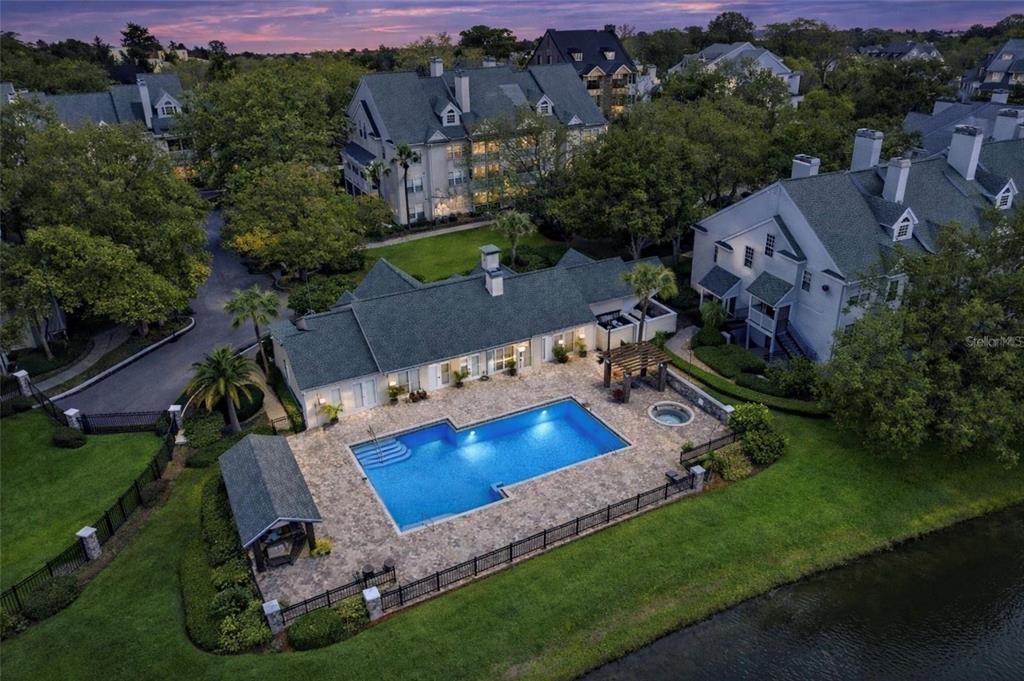 An aerial view shows a swimming pool and spa on a patio behind a building — 3274 HAVILAND COURT UNIT 201, PALM HARBOR, FL