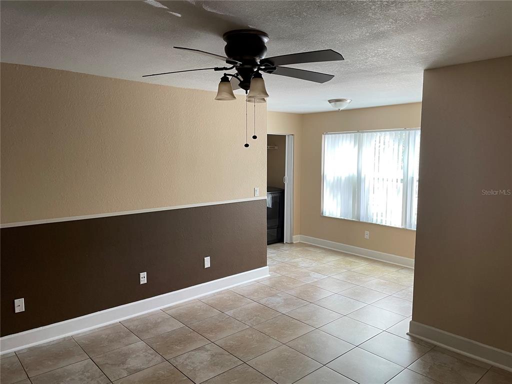 A room with tile flooring, a ceiling fan, and walls painted with a two-tone color scheme — 4512 COMMANDER DRIVE UNIT 1725, ORLANDO, FL